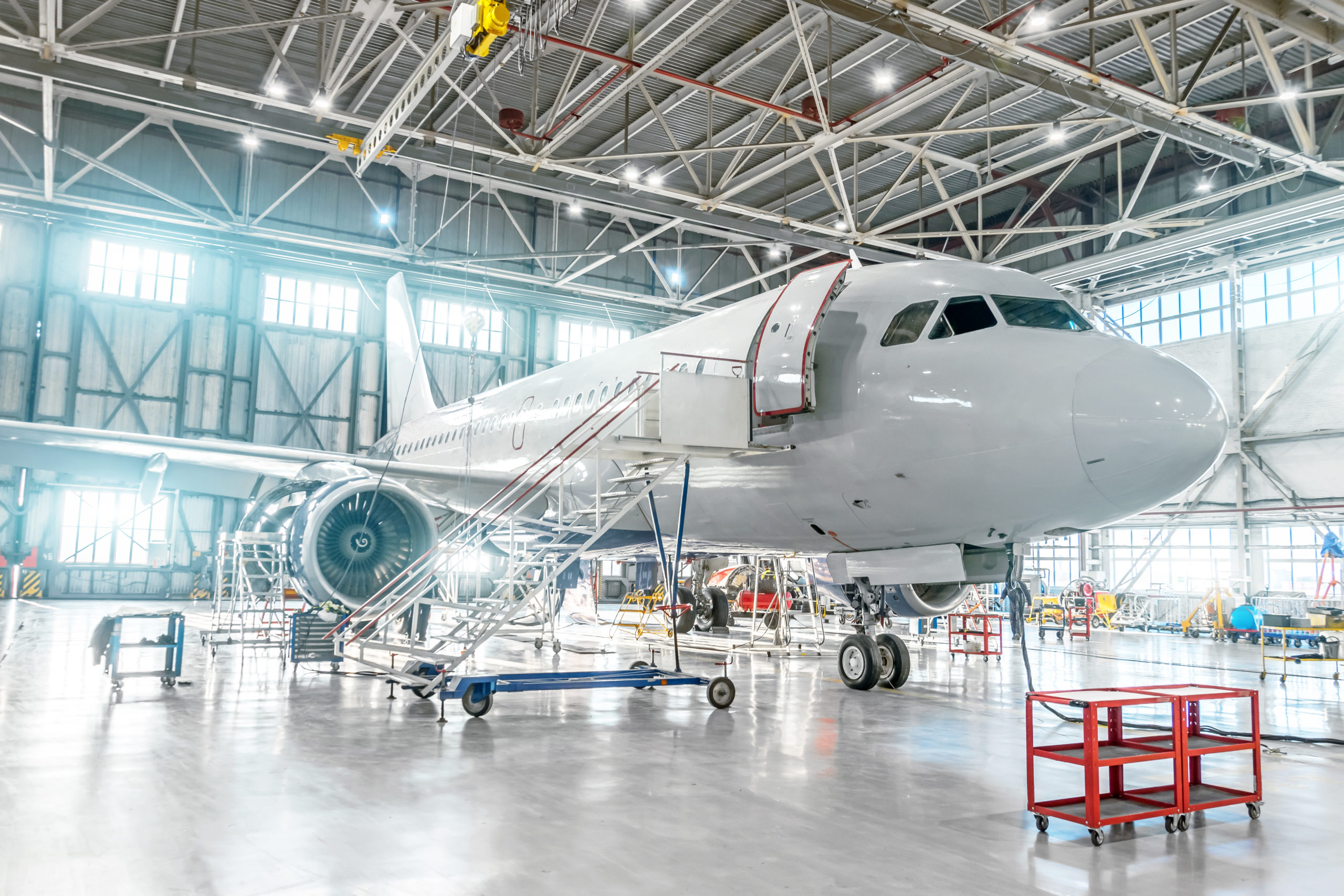 Aircraft under maintenance, checking mechanical systems for flight operations. Plane in the hangar