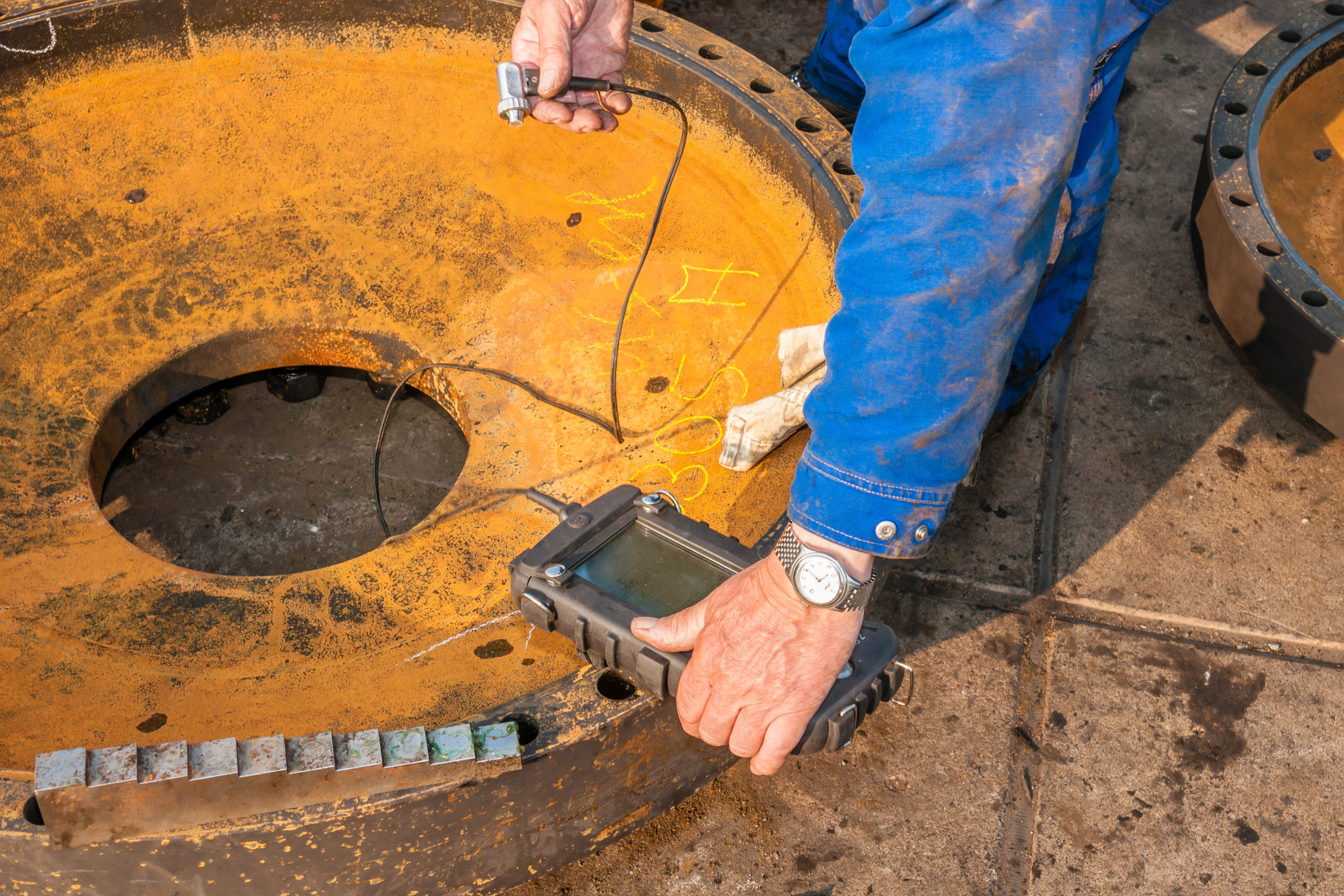Non-destructive testing of a heat-exchanger part. Ultrasonic wall-thickness measuring is a recognized technique for vessel inspection.